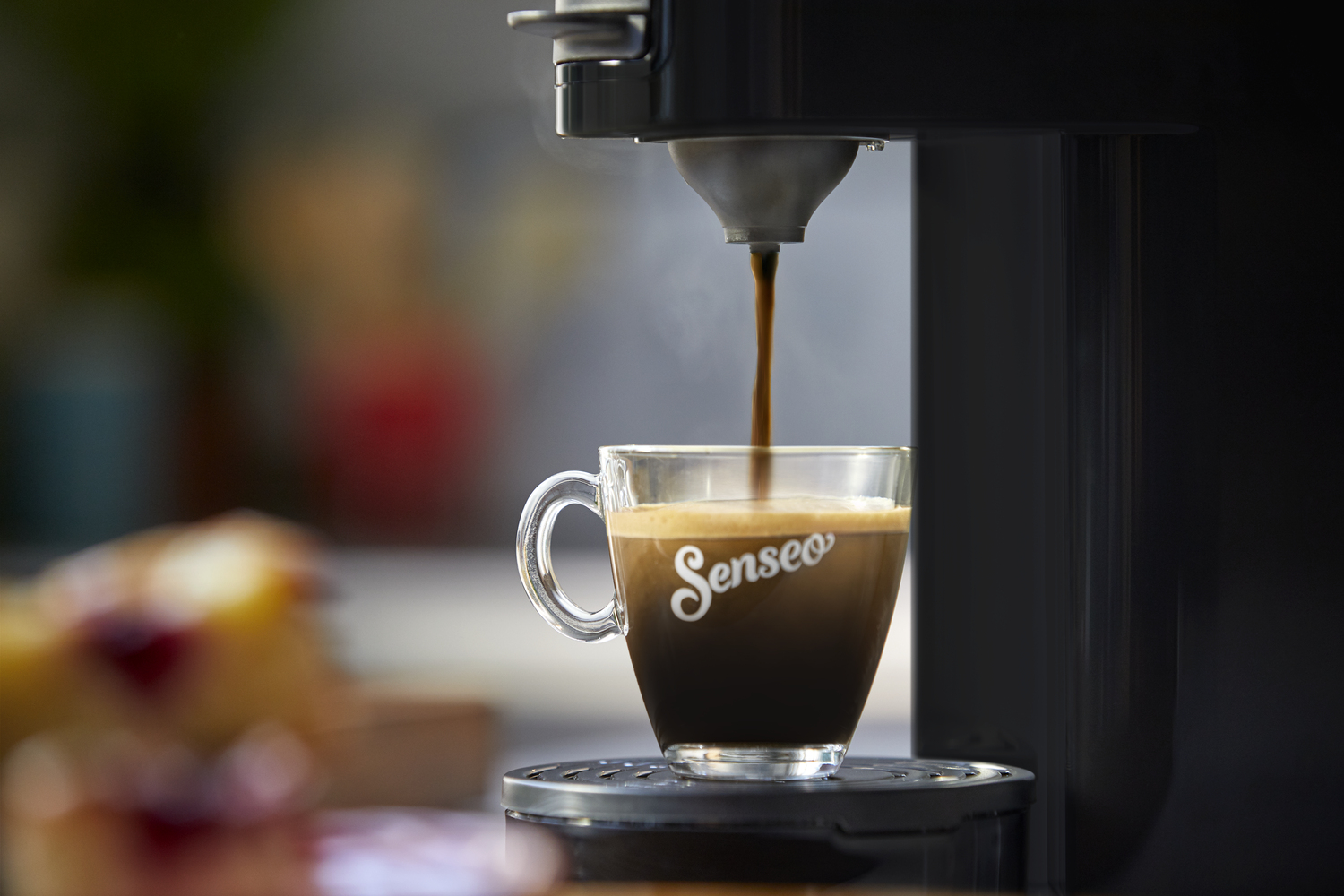 Espressokoffie die uit een machine in een glazen kopje wordt gegoten.