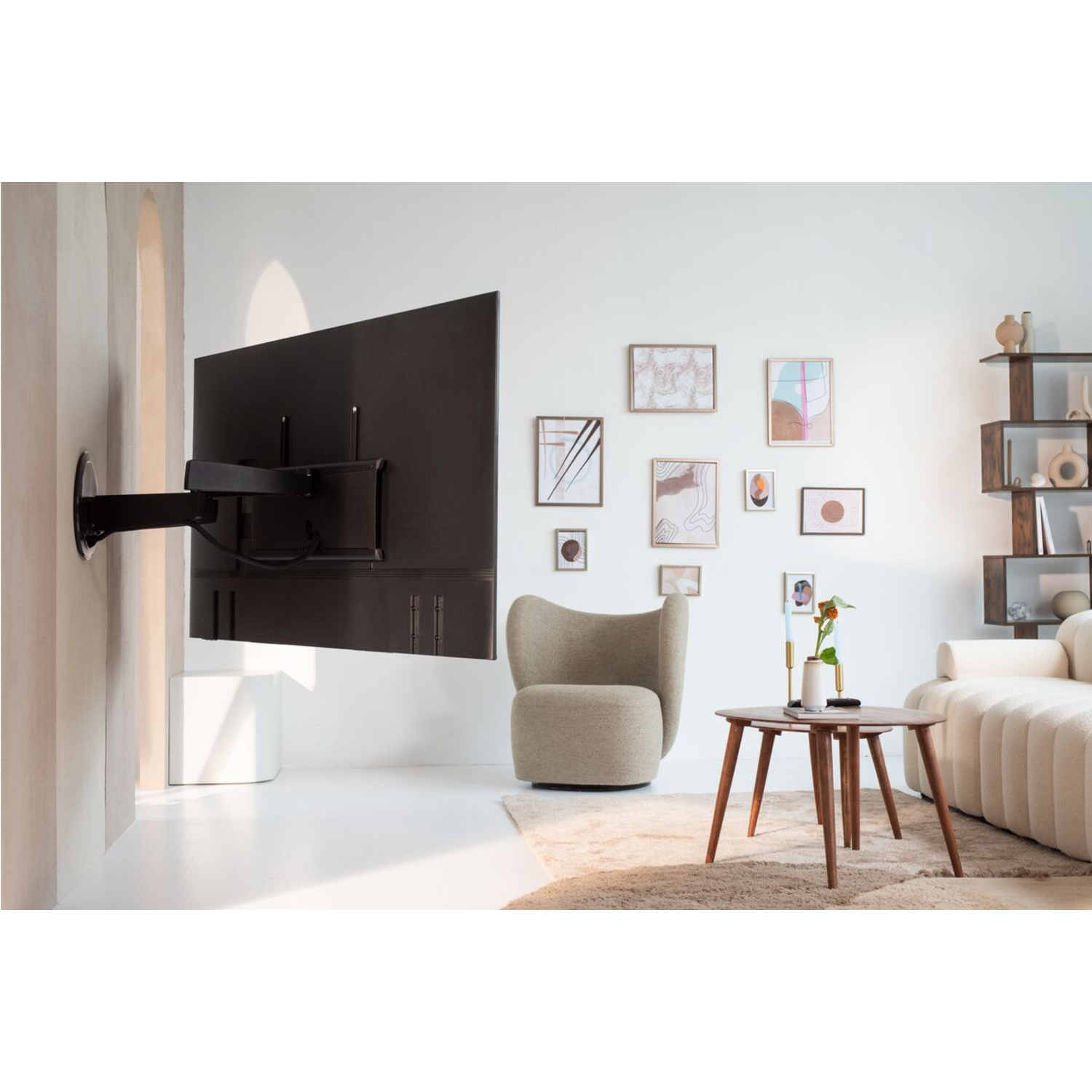 A TV mounted on a wall with furniture and decor in a room.