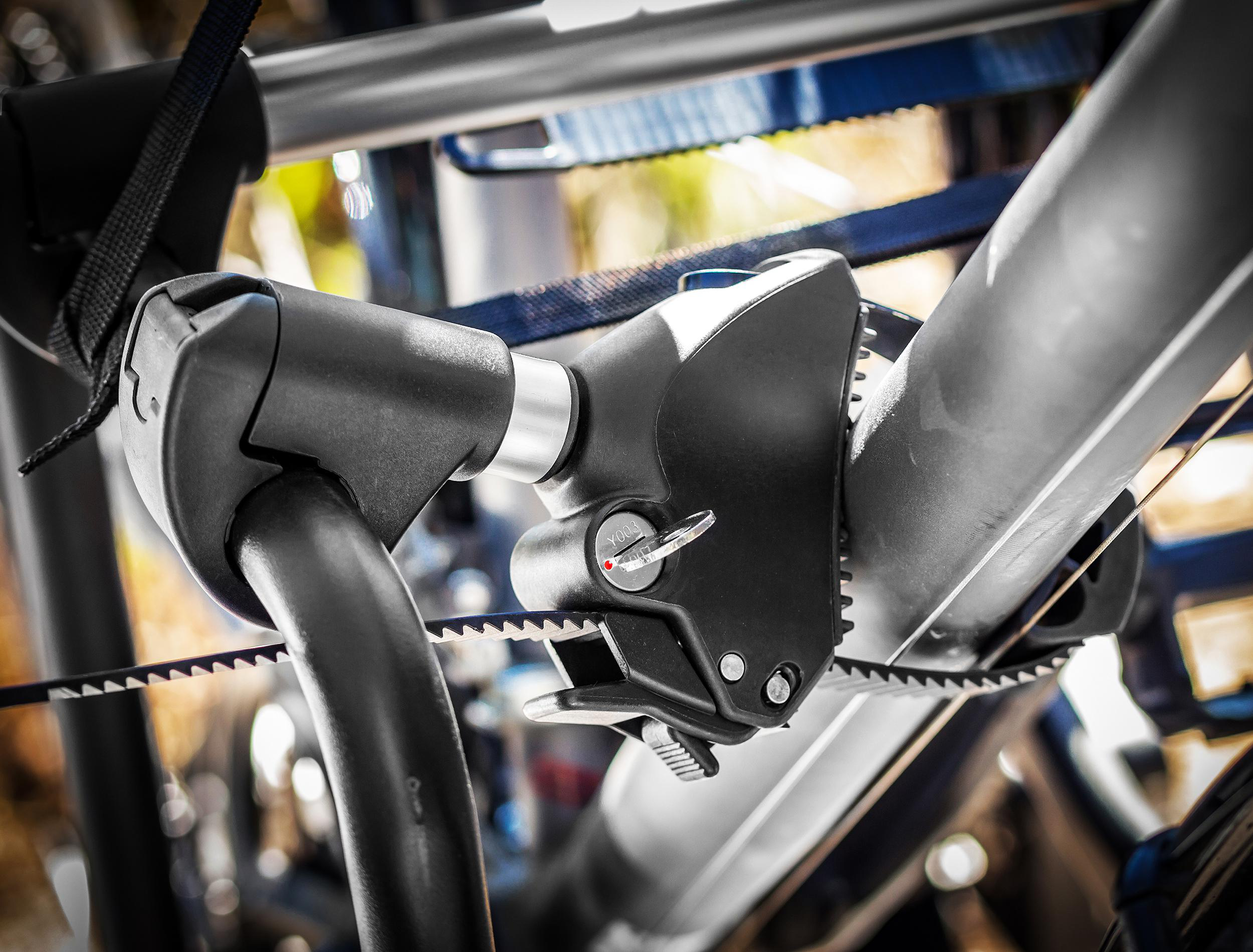 Nahaufnahme eines Fahrradträgermechanismus mit Verriegelungssystem und Gurten, der ein Fahrrad hält.