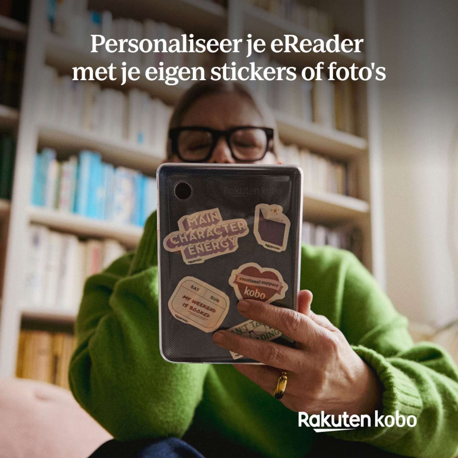 Vrouw met een tablet met stickers; een boekenplank staat op de achtergrond.