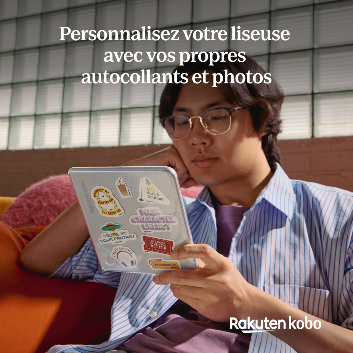 Un homme tenant une tablette avec des autocollants, logo Rakuten Kobo en bas.