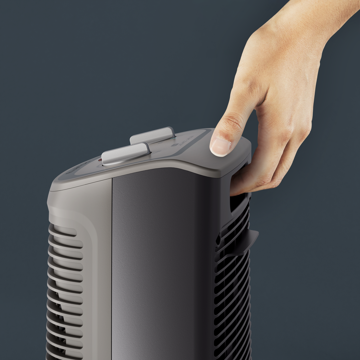 Hand pressing a button on top of a gray and black fan, close-up shot.