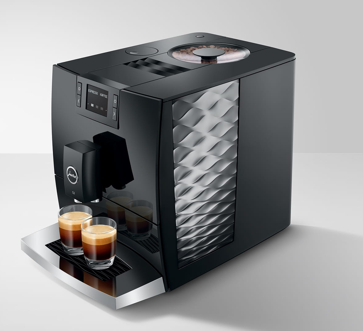 Una macchina da caffè Jura nera con due bicchieri di espresso davanti. La macchina ha un display.