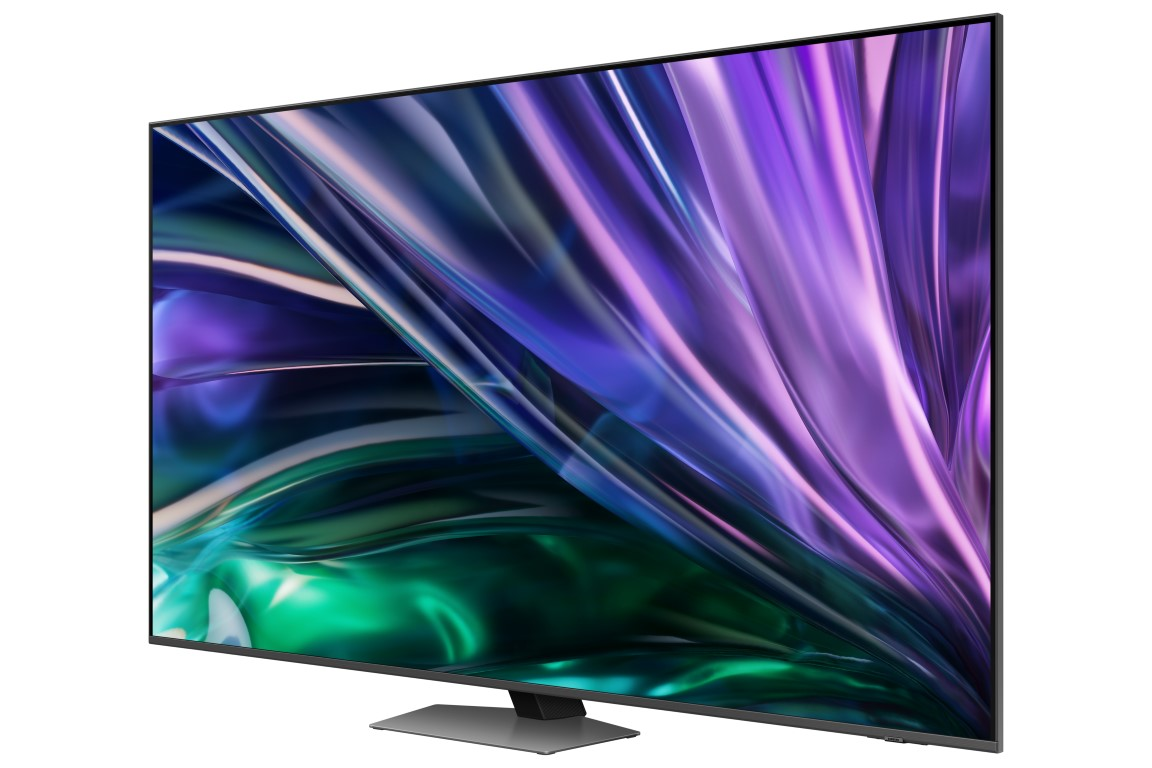 Büyük TV, açılı görünüm. Ekran, dönen mor ve mavi desenler görüntüler. Gümüş stand tabanı.