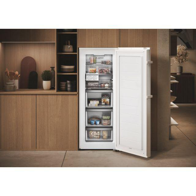Ein weißer Kühlschrank mit offener Tür, die Regale und Schubladen mit Lebensmitteln zeigt.