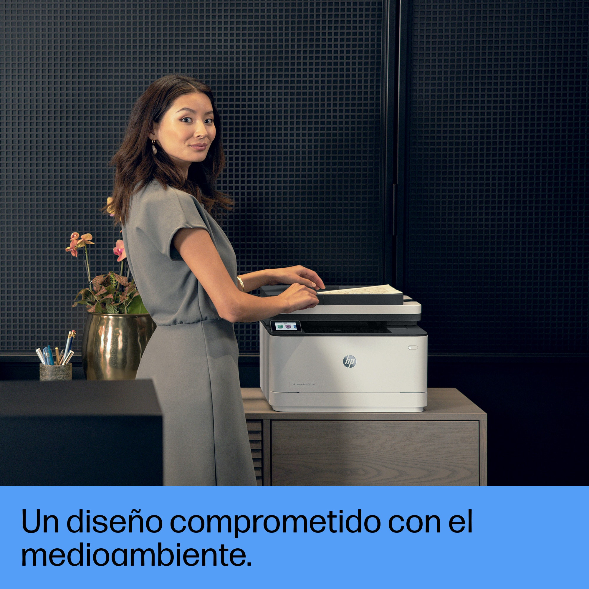 Mujer usando una impresora HP blanca, junto a pared negra y florero.
