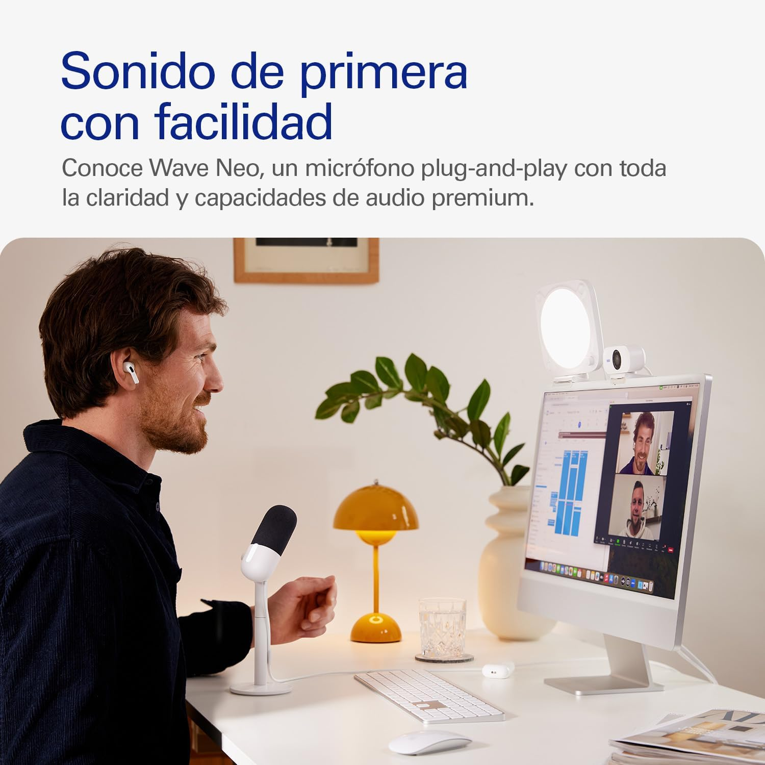 Hombre con auriculares en el escritorio usando una computadora con micrófono y lámpara.