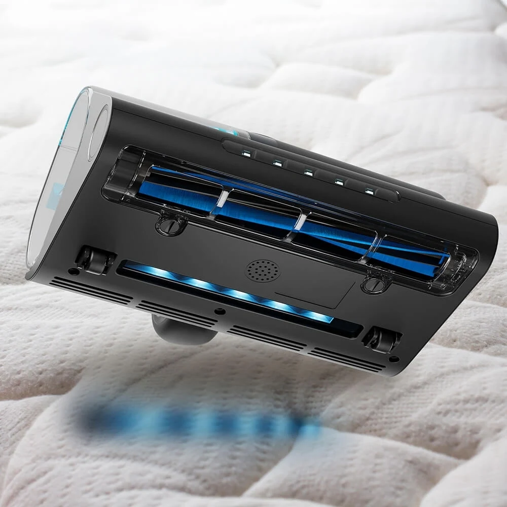 Czarna głowica odkurzacza na białym łóżku. Niebieskie światła ją oświetlają.