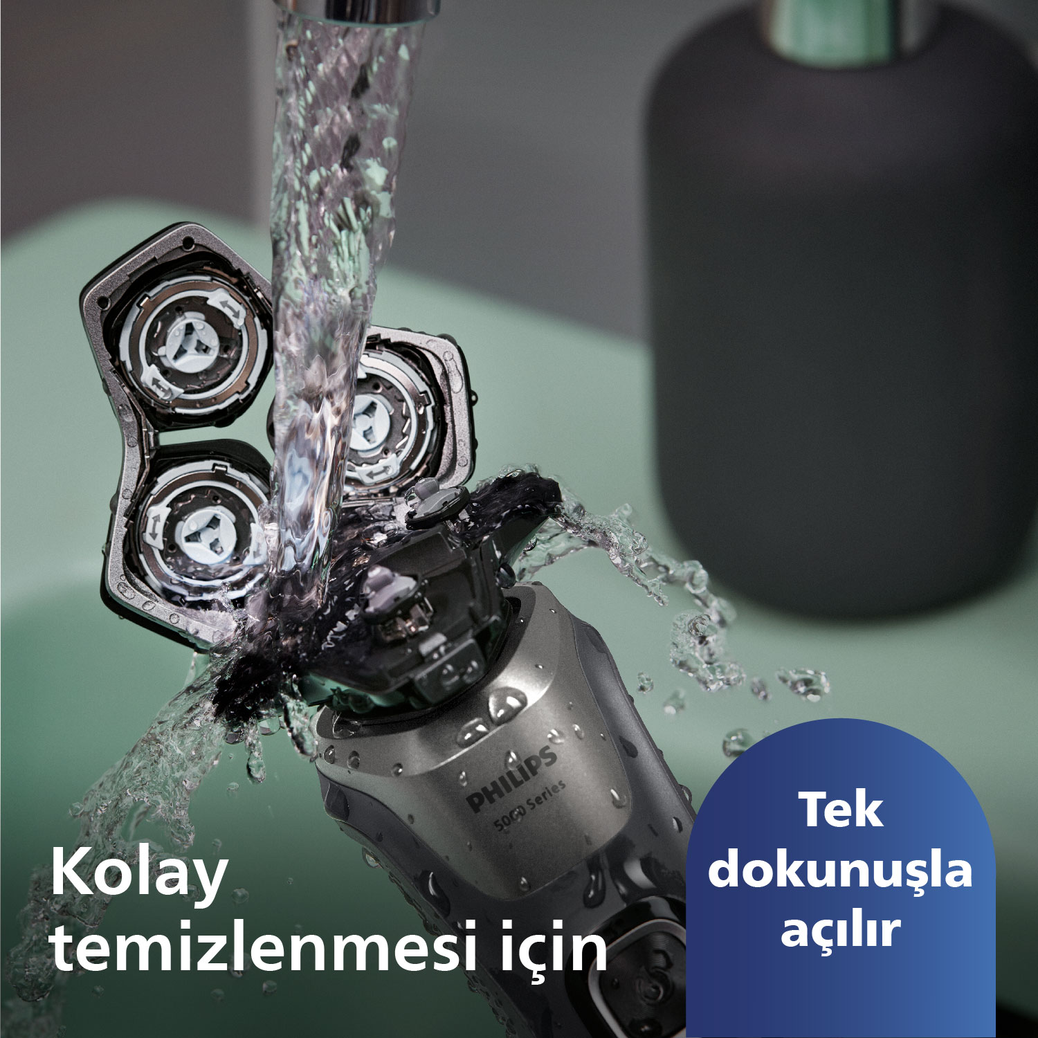 Philips tıraş makinesinin suyla temizlenmesinin yakın çekimi. Tıraş başlığı açık. Türkçe metin.