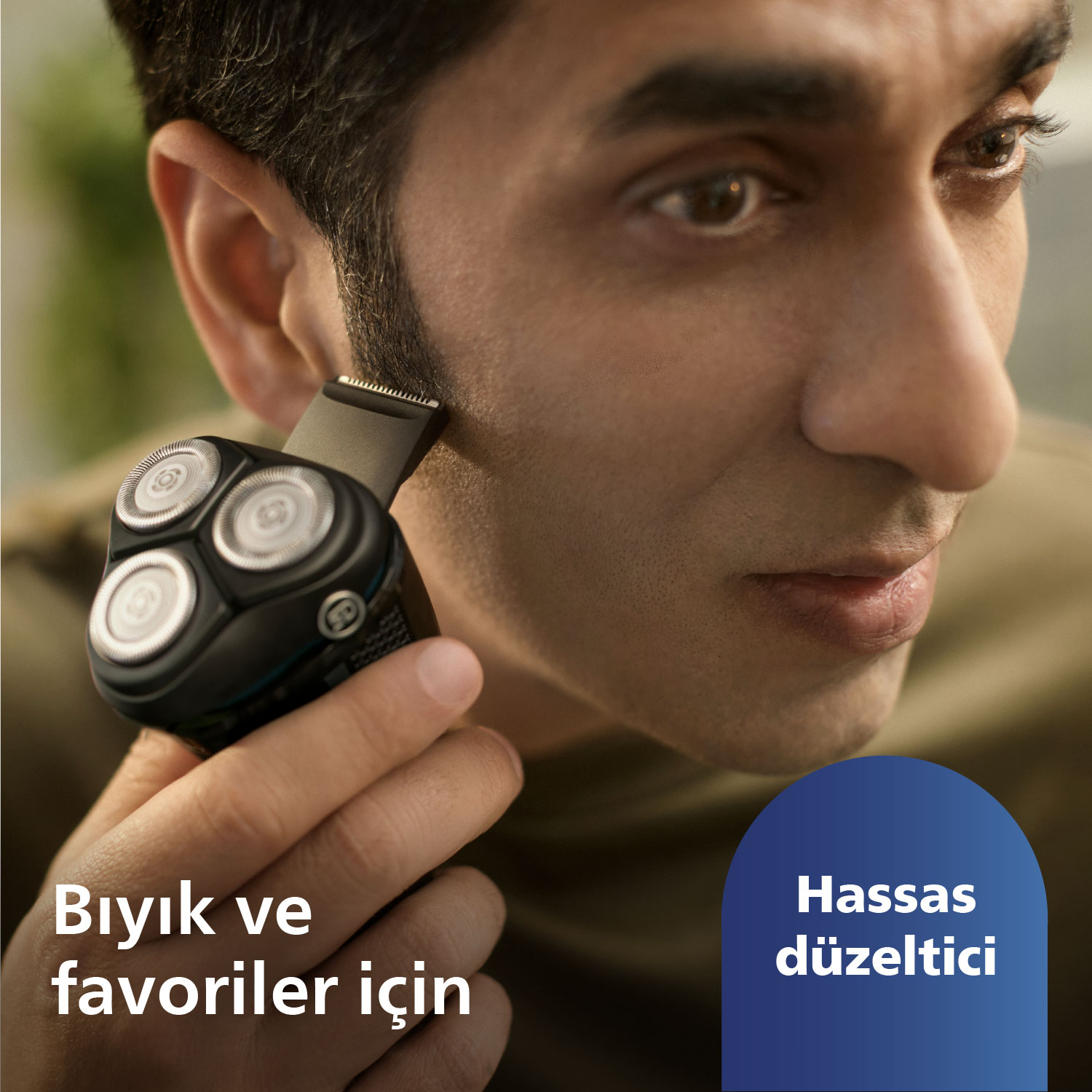Bir adam siyah elektrikli tıraş makinesiyle tıraş oluyor. Metin: Bıyık ve favoriler için. Türkçe metin: Hassas düzeltici.