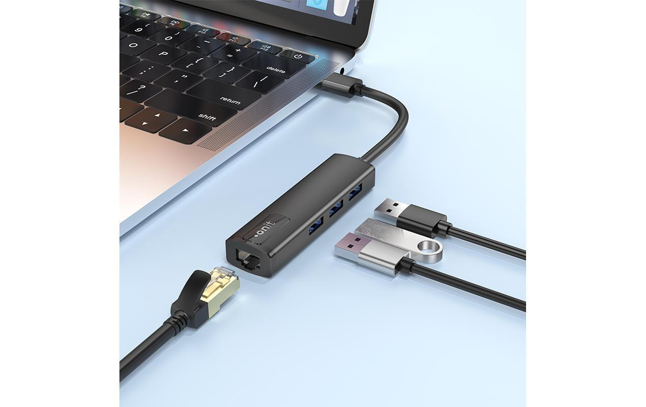 Hub USB nero collegato a un laptop, con vari cavi collegati su una superficie blu.