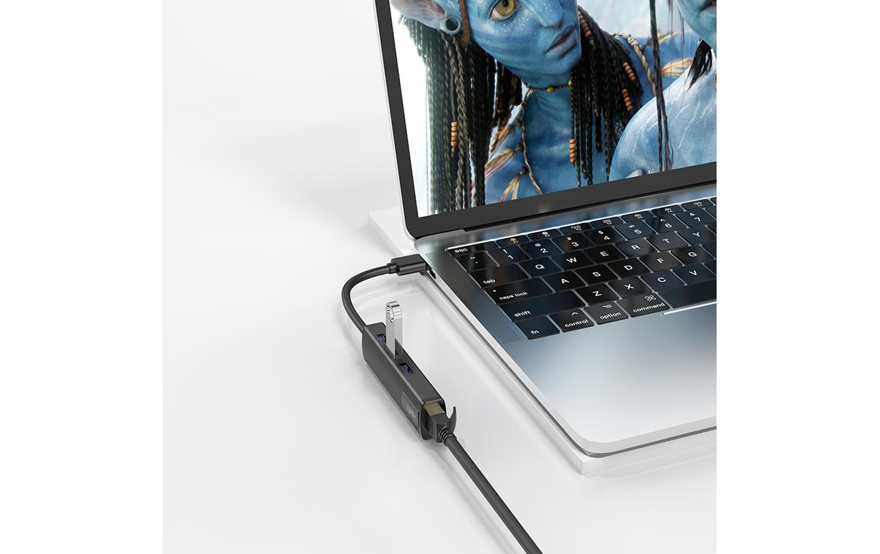 Laptop collegato a un hub con più porte, che mostra un film.