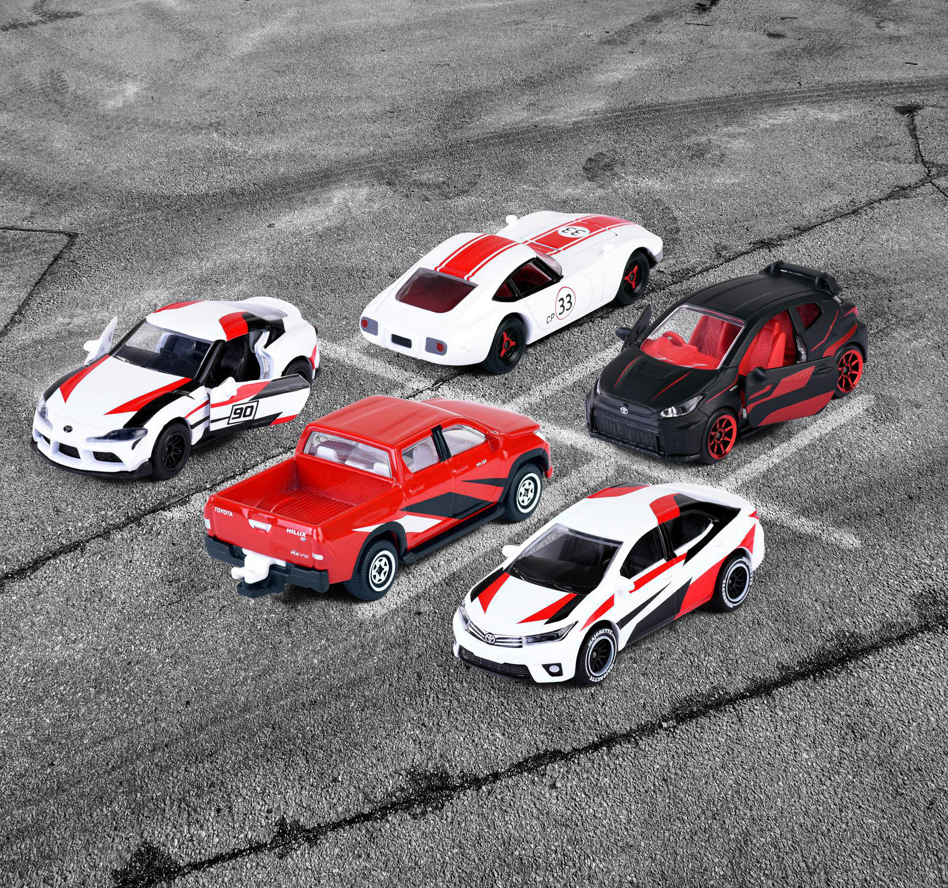 Ein Bild von Spielzeugautos. Mehrere bunte Modellautos auf grauem Hintergrund.
