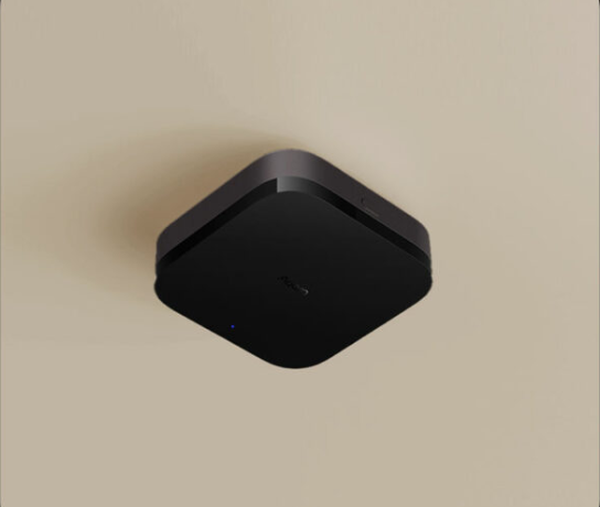 Un appareil domestique intelligent noir et carré est monté sur un plafond beige.