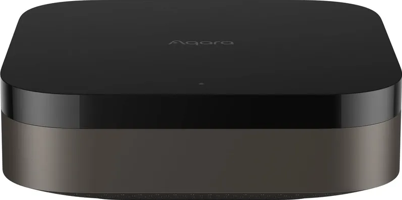 Hub domotique noir avec une base argentée, dessus avec le mot "Aqara", fond blanc.