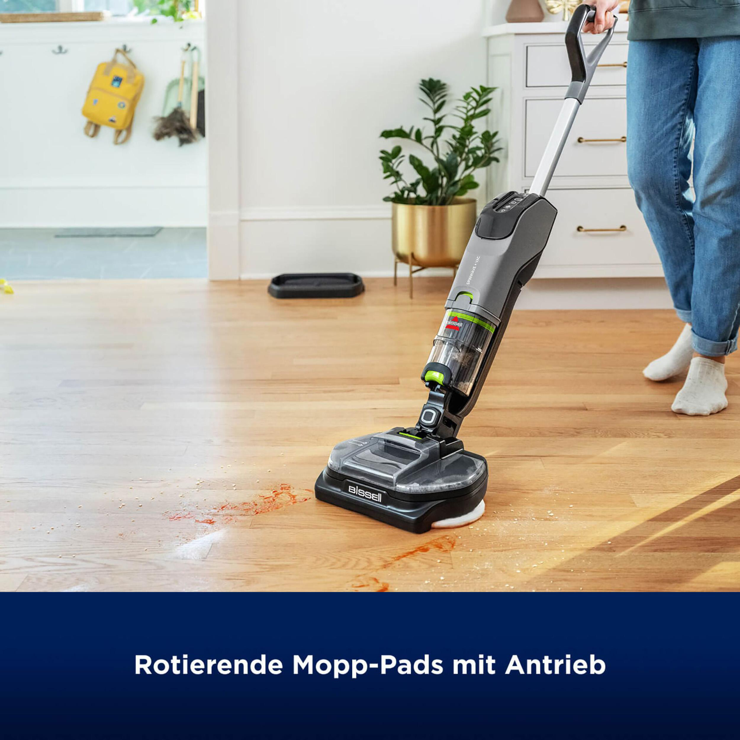 Eine Person reinigt einen Holzboden mit einem Bissell Nass-Trocken-Staubsauger.