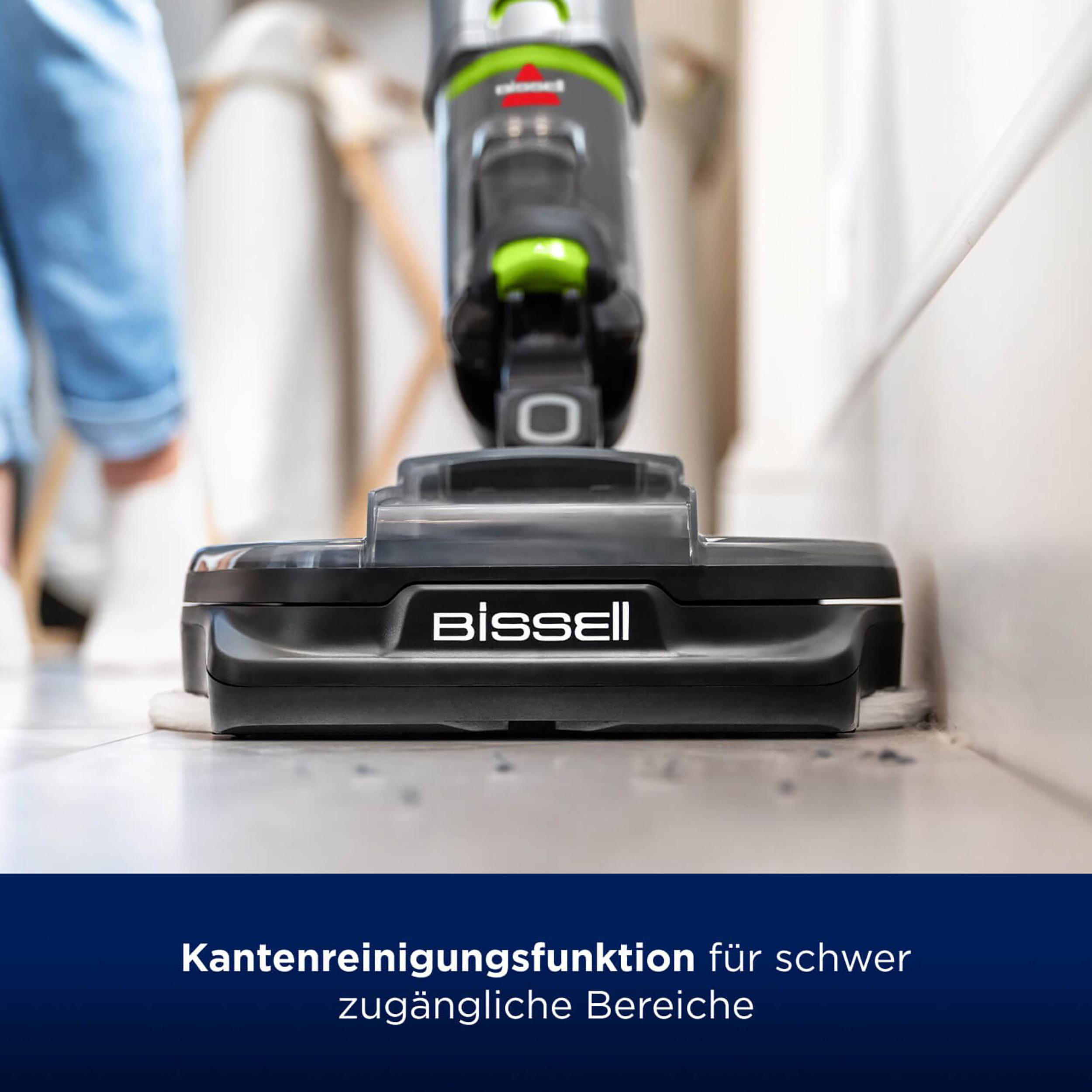 Ein Staubsauger reinigt in Wandnähe. Die Marke ist Bissell.