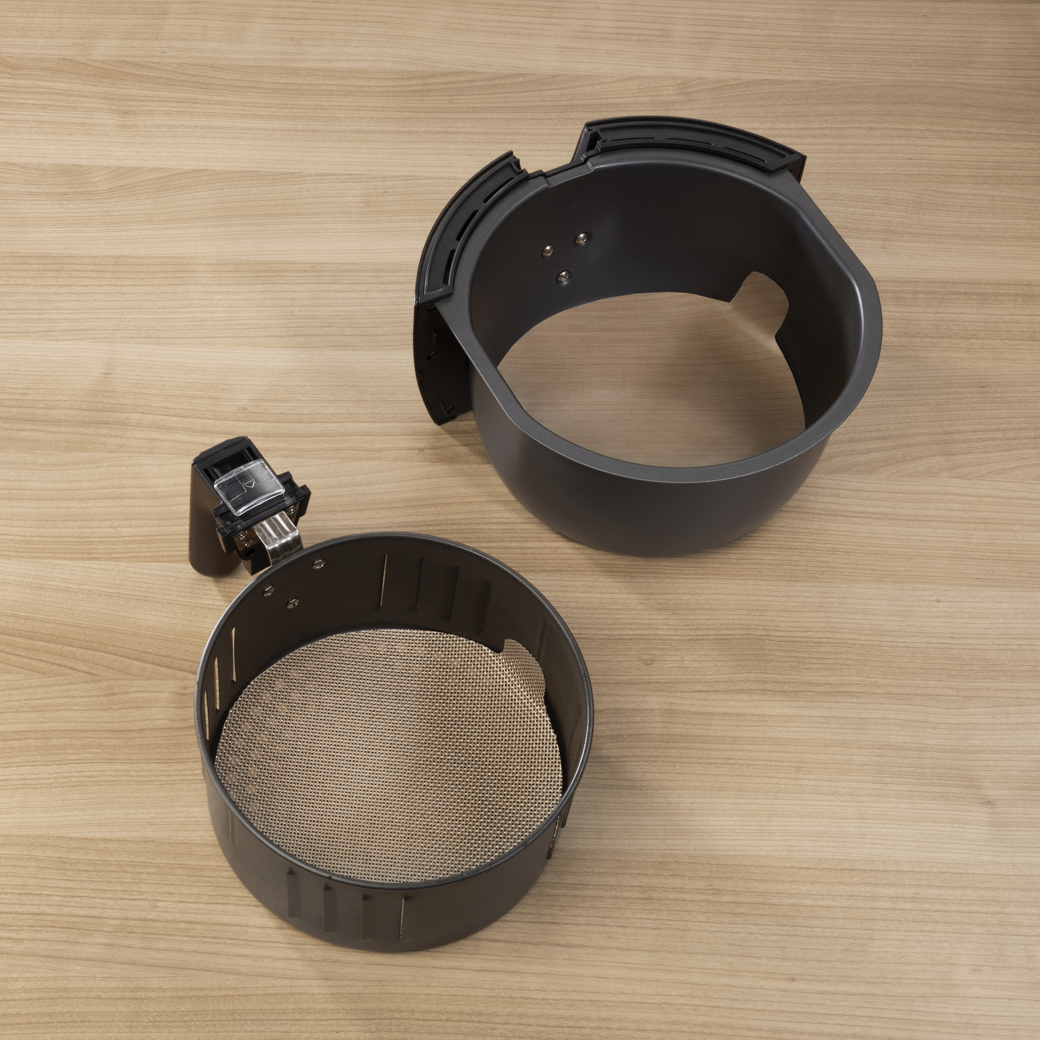 Air fryer parts on a wooden surface.