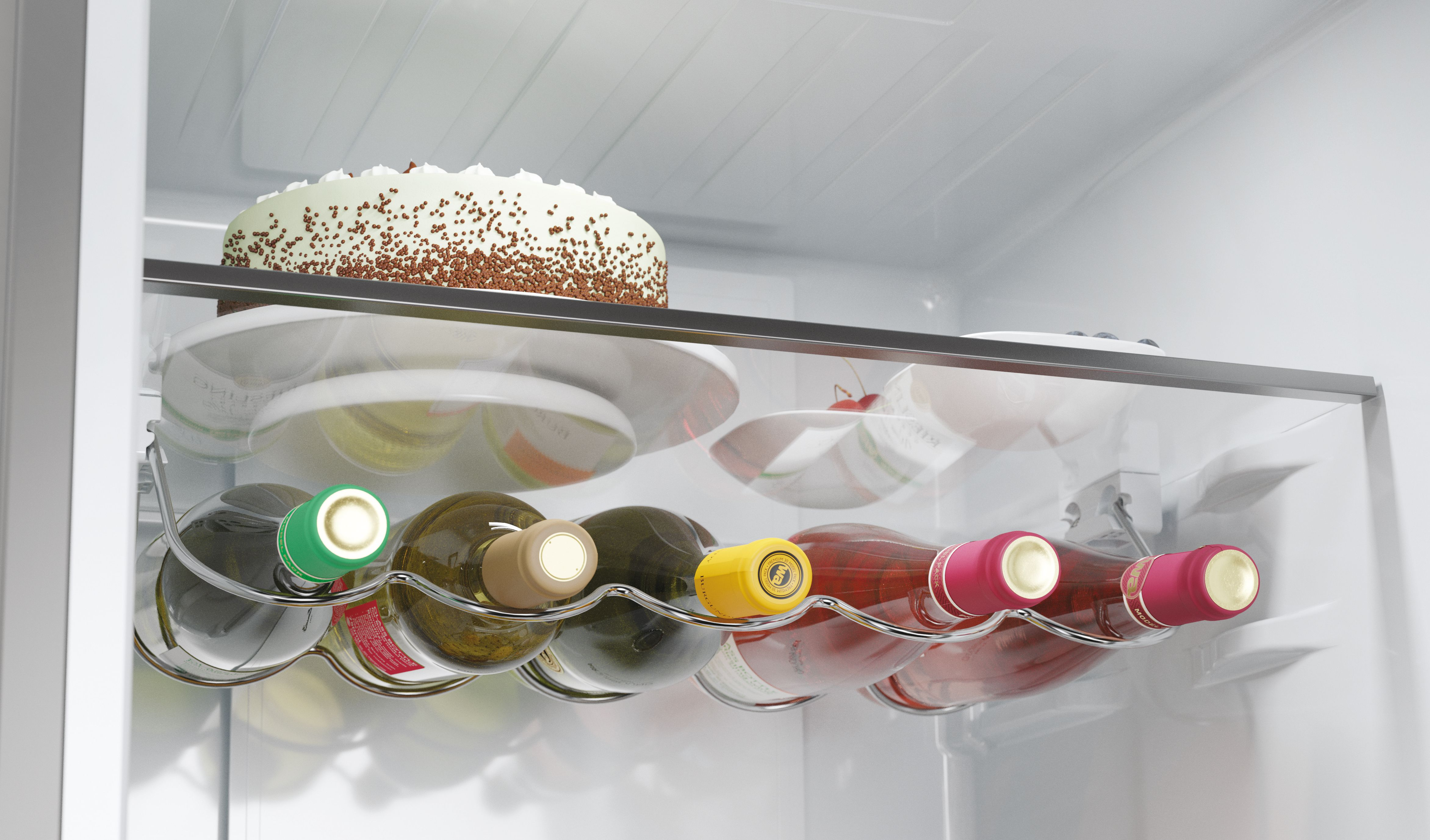 Interior de un refrigerador. Botellas de vino, pastel y otros artículos son visibles.