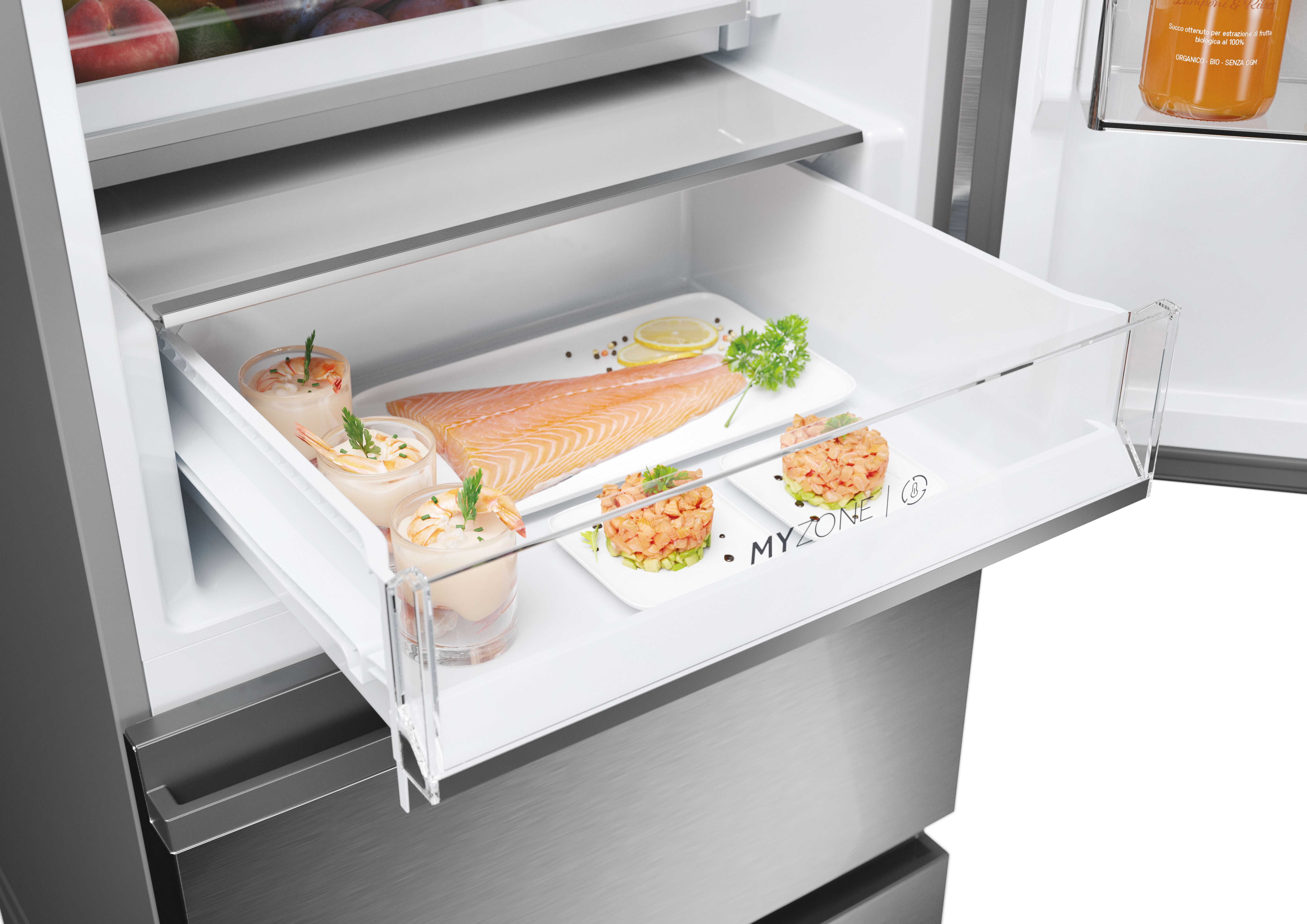 Un cajón de nevera con alimentos, incluyendo camarones y salmón.