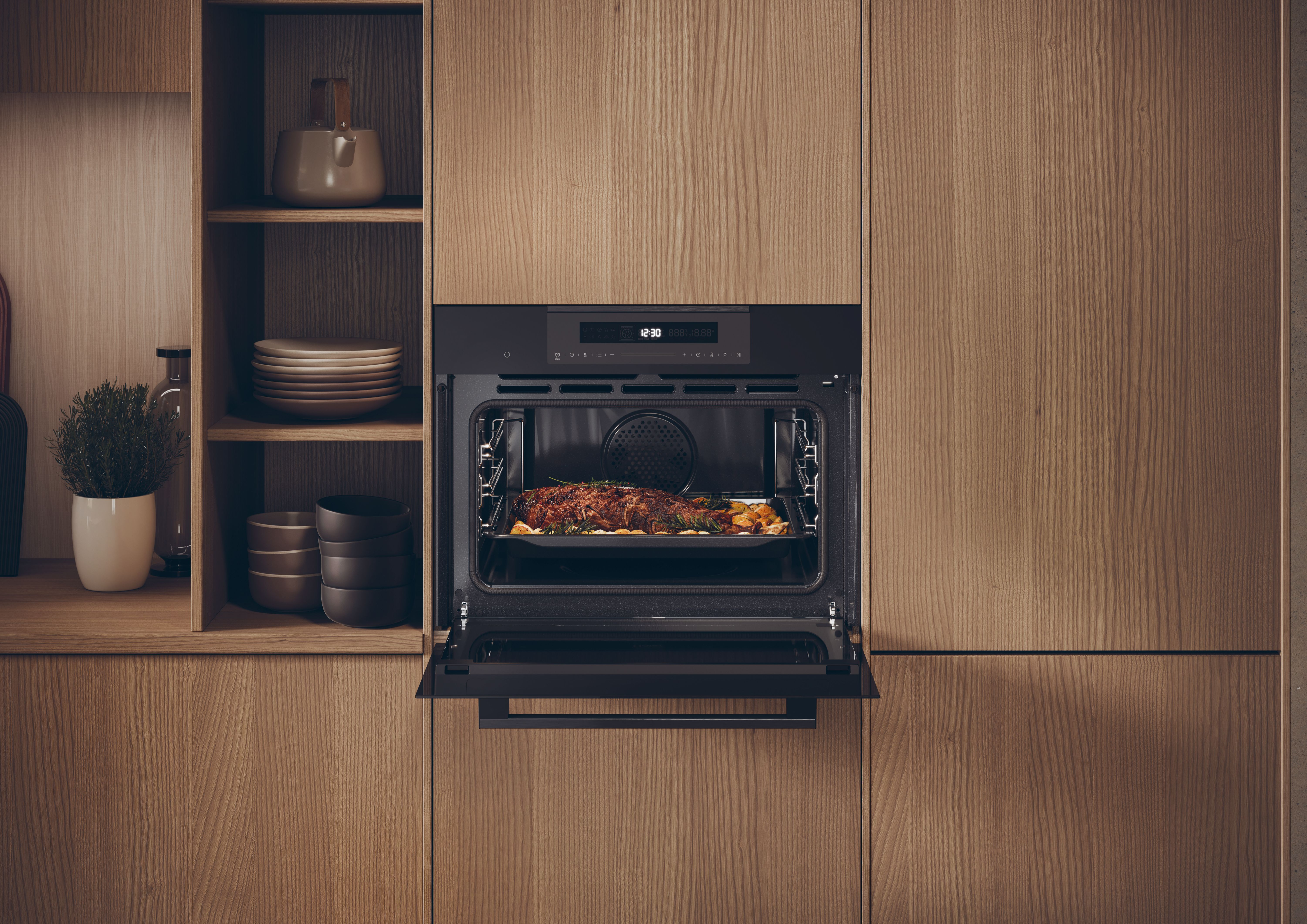 Horno con la puerta abierta, mostrando comida asada. Estantes de madera y una planta a los lados.