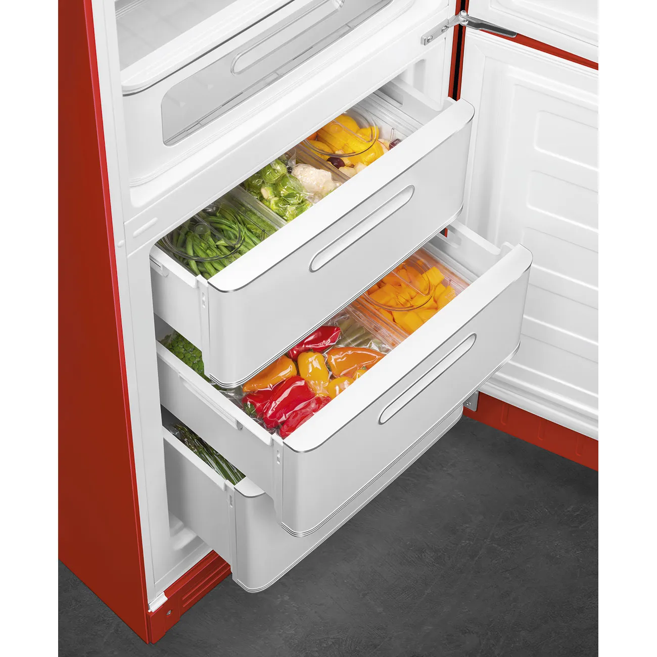 Refrigerador rojo con cajones abiertos que muestran productos frescos y alimentos.