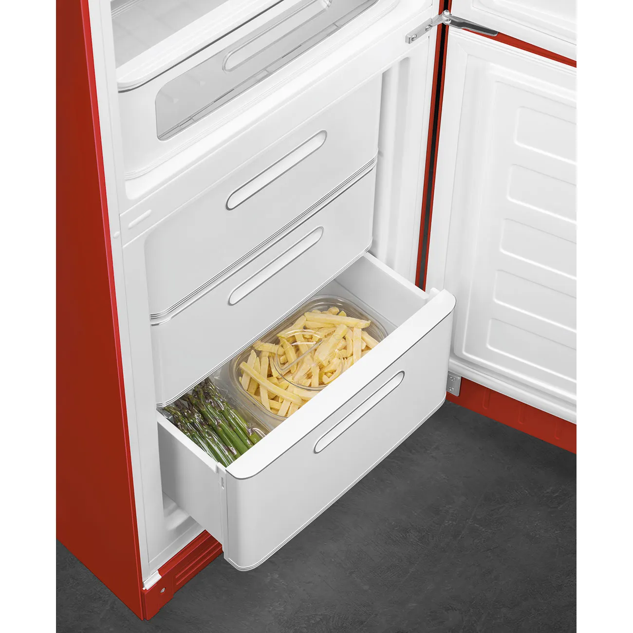 Refrigerador abierto con cajones de comida: papas fritas y espárragos.