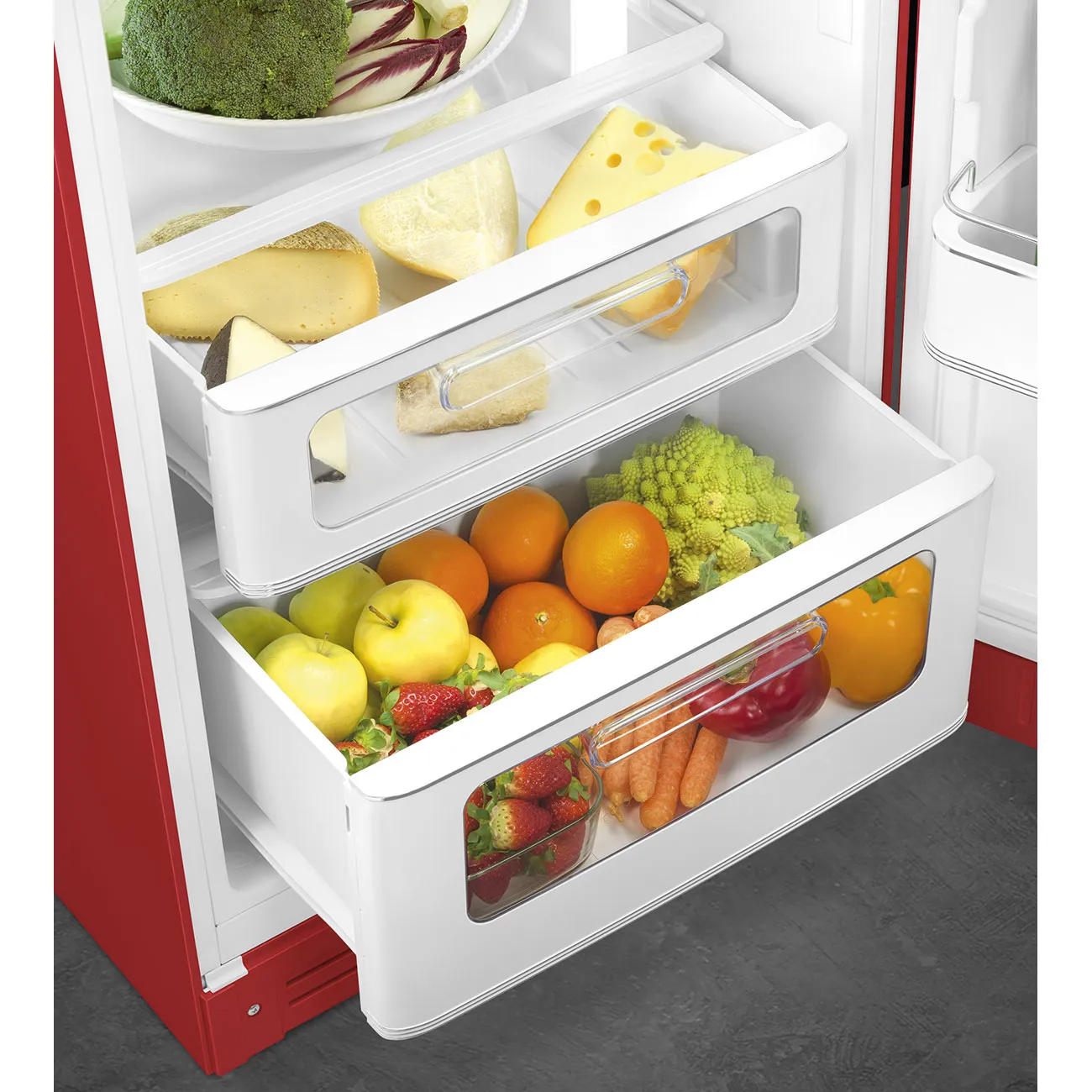 Un refrigerador rojo con cajones abiertos llenos de frutas, verduras y queso.