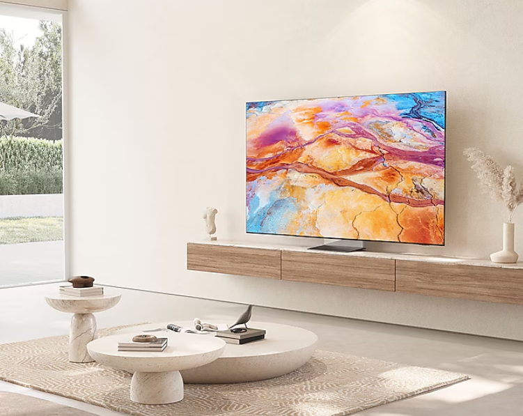 Salon z dużym telewizorem na ścianie. Okrągły stolik kawowy i sofa dopełniają scenę.