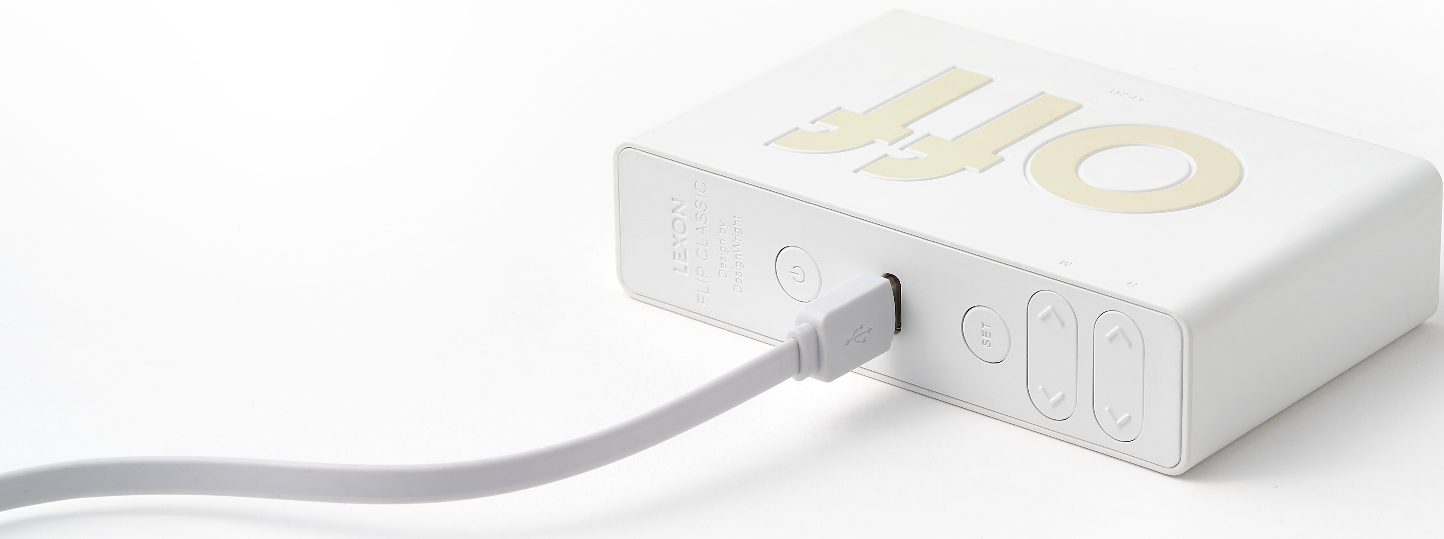 Ein weißes elektronisches Gerät mit eingestecktem USB-Kabel. Text auf dem Gerät.