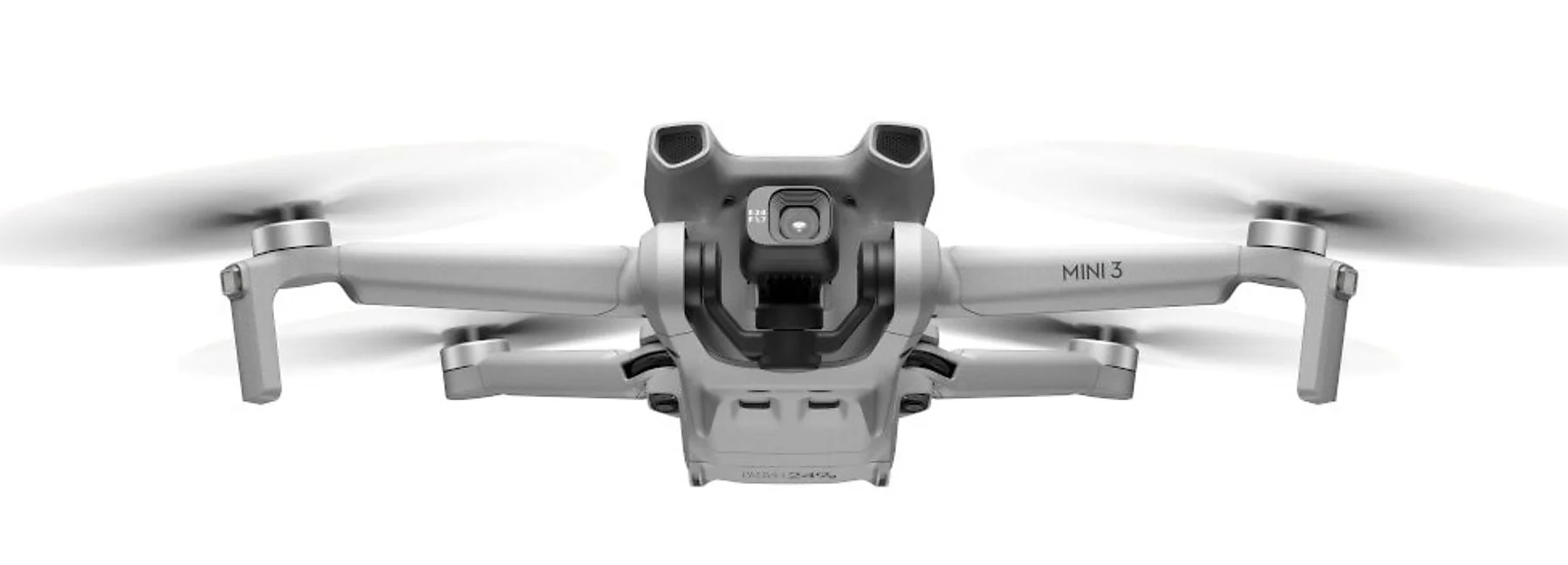 Latający dron, wyśrodkowany na białym tle. Szary dron z kamerą i śmigłami.