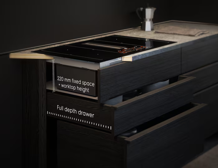 Konyhaszekrény nyitott fiókkal. A pulton egy tűzhely van. A szöveg a következő: 220 mm rögzített hely + munkalap magassága.