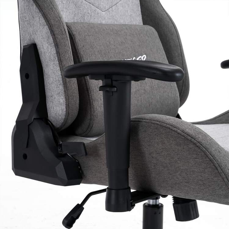 Primer plano de una silla gamer gris y negra con reposabrazos ajustables. La silla está vacía.
