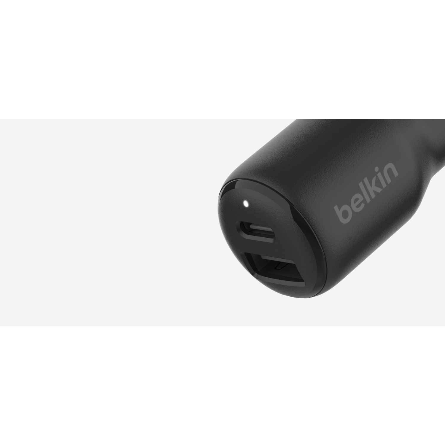 A black Belkin car charger with two USB ports and a white LED light.