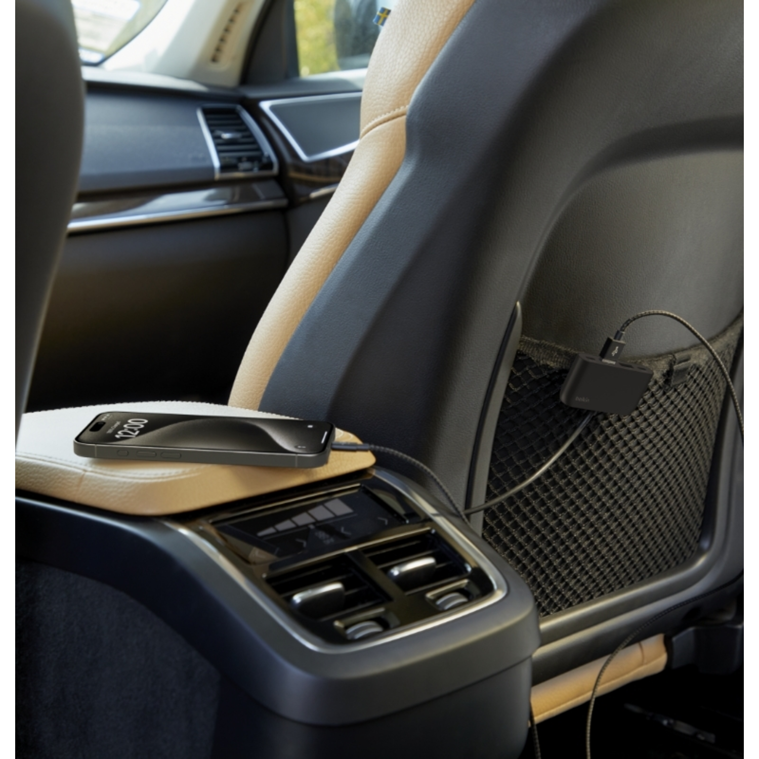 A phone charging in a car. A charger and a black phone are visible.