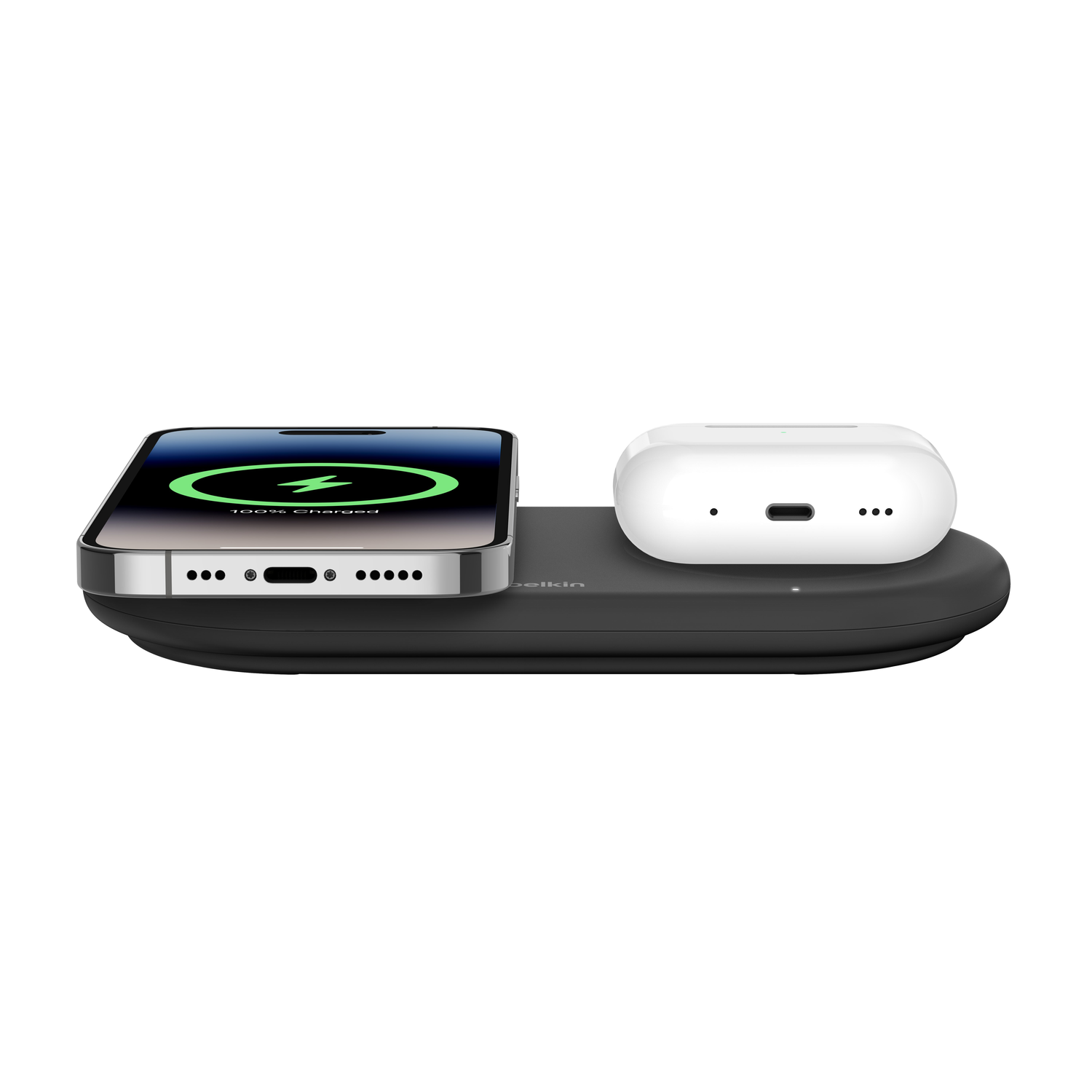 Een telefoon en oortelefoons op een zwart oplaadpad, met de telefoon die 100% opgeladen toont.