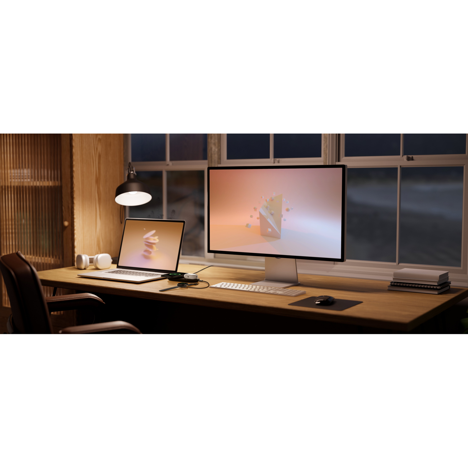 Een goed verlicht bureau met een laptop, monitor, koptelefoon en een lamp.