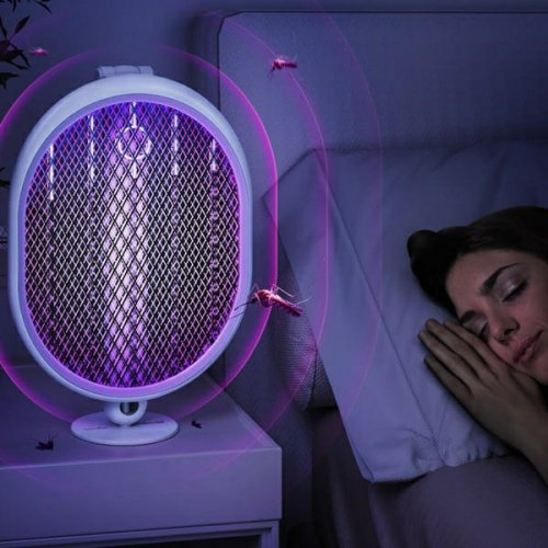 Lampa owadobójcza obok śpiącej osoby. Emituje fioletowe światło, wokół latają owady.
