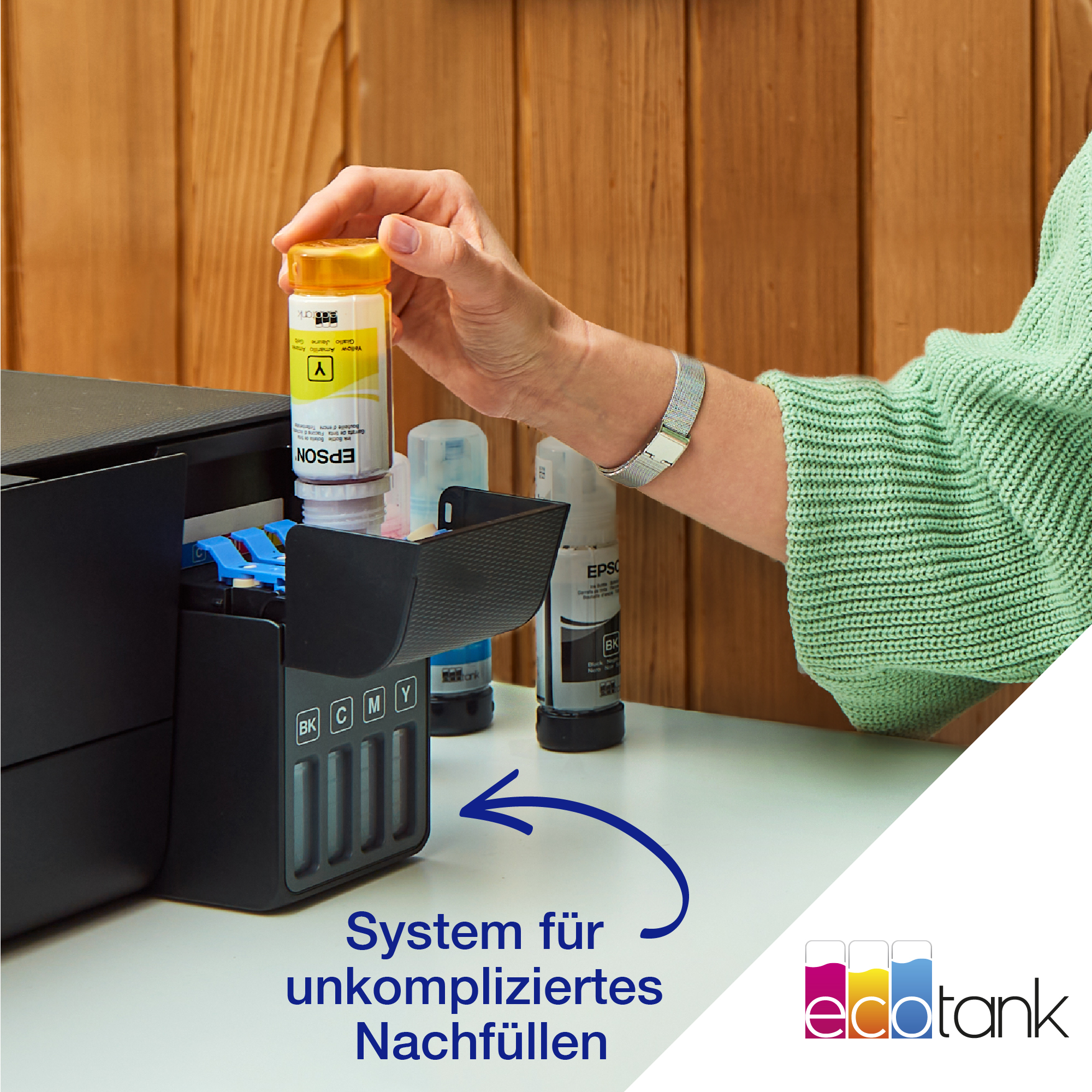 Person befüllt Drucker-Tintentanks mit gelber Tinte. Text: System für unkompliziertes Nachfüllen.