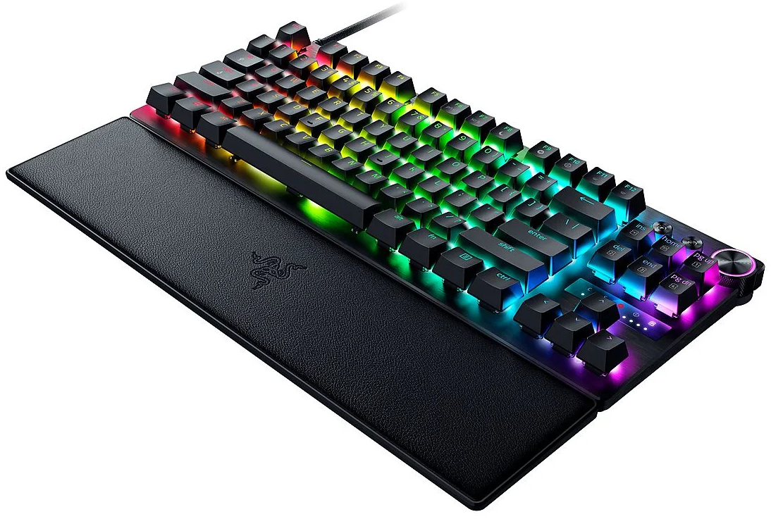 Eine schwarze Gaming-Tastatur mit bunten LED-Leuchten. Sie hat eine Handballenauflage und ein Razer-Logo. Die Tasten sind schwarz.