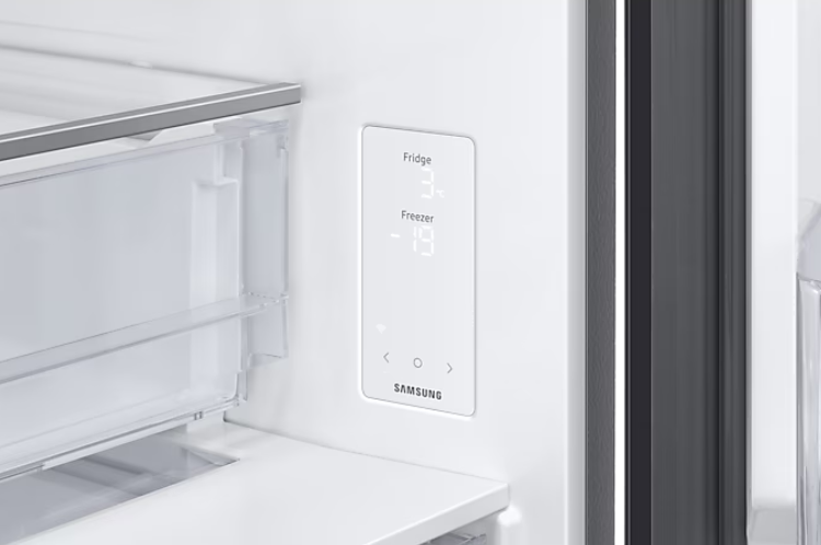 Wnętrze lodówki z wyświetlaczem temperatury i otwartymi drzwiami.