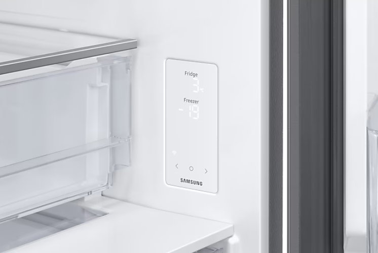 Wnętrze lodówki z panelem sterowania pokazującym temperatury chłodziarki i zamrażarki.