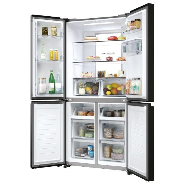 Geöffneter Kühlschrank, Lebensmittel in Fächern und Schubladen sichtbar.