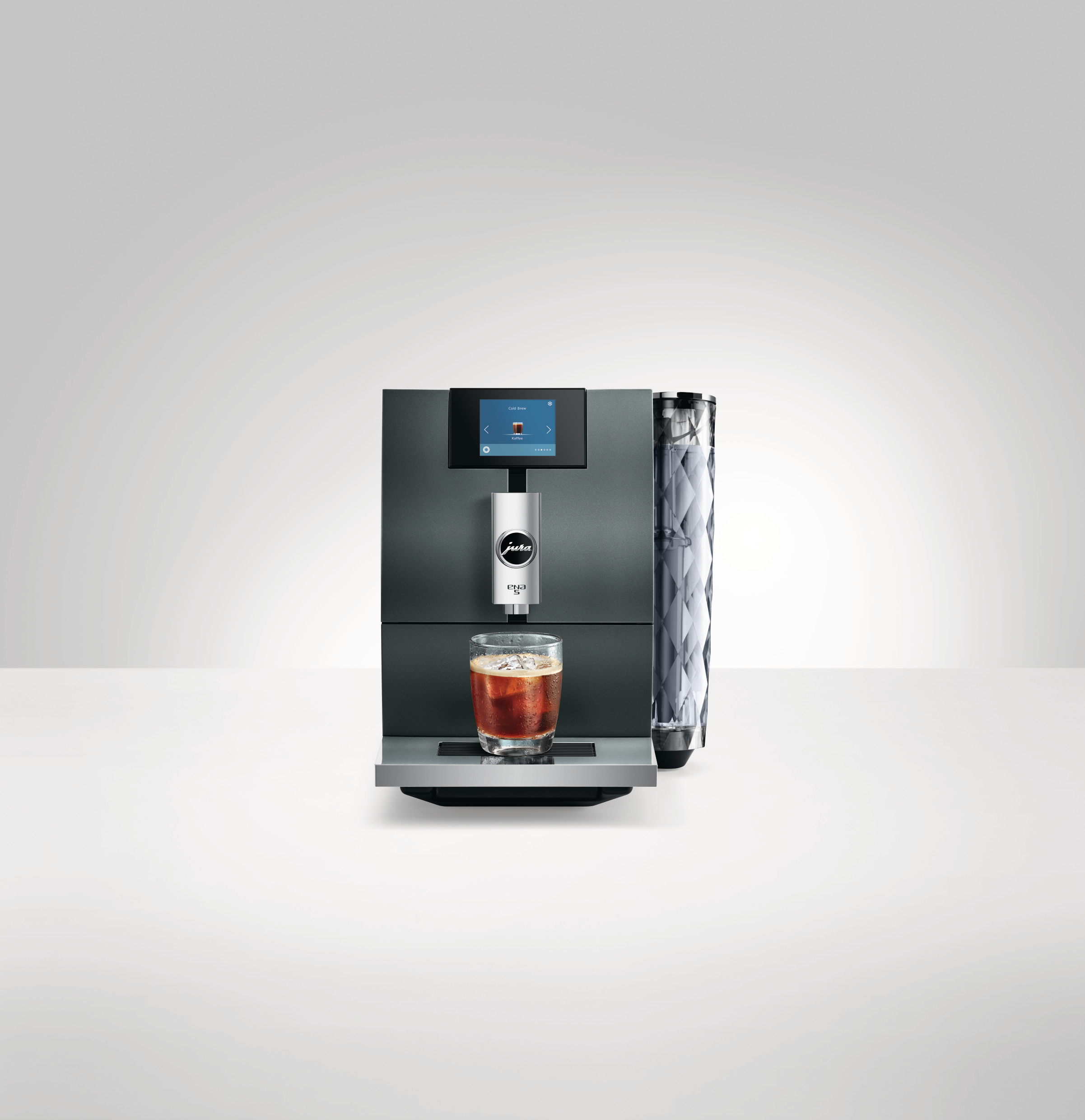 Eine Kaffeemaschine mit einem Glas Eiskaffee davor.