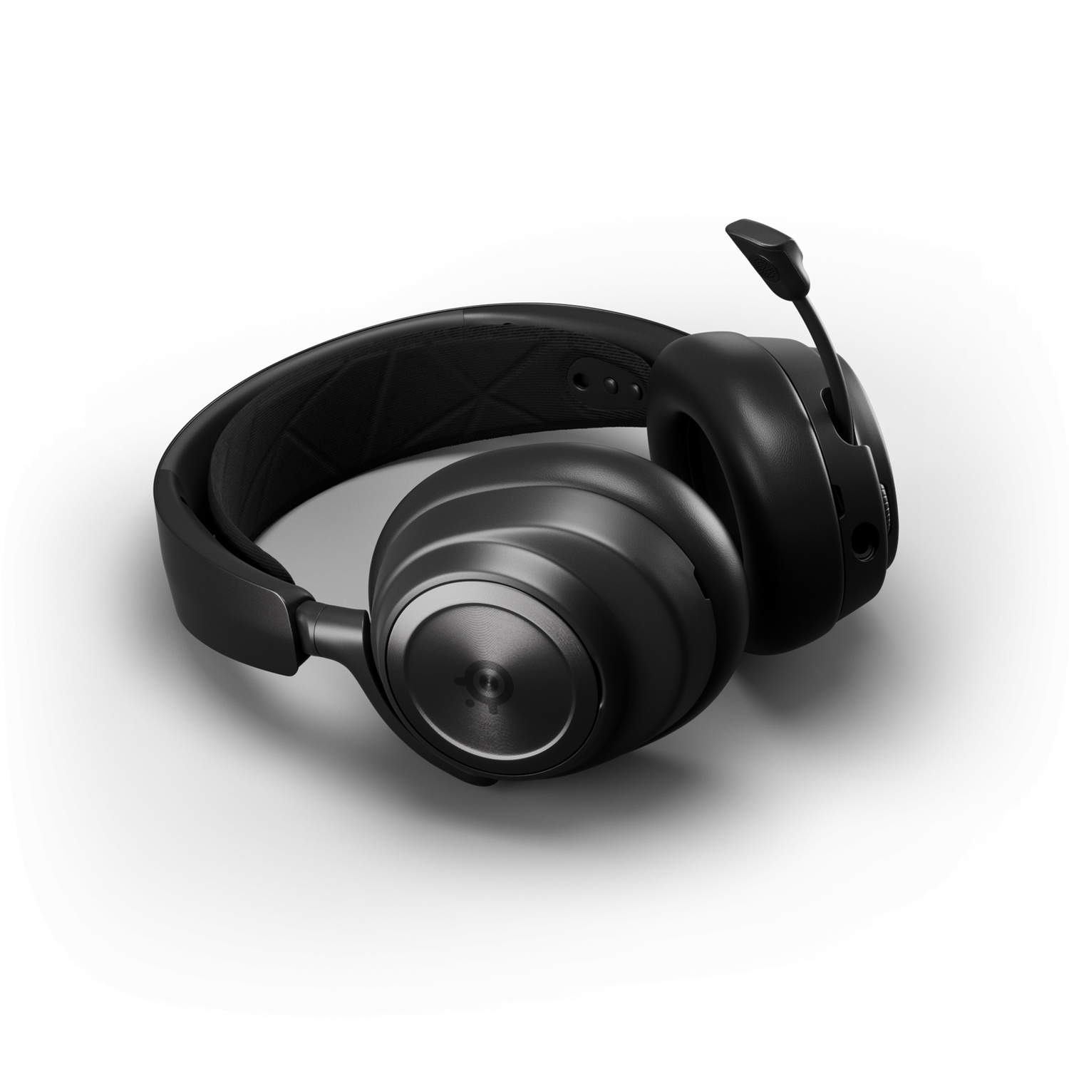 Casque noir avec un microphone, posé sur une surface blanche.
