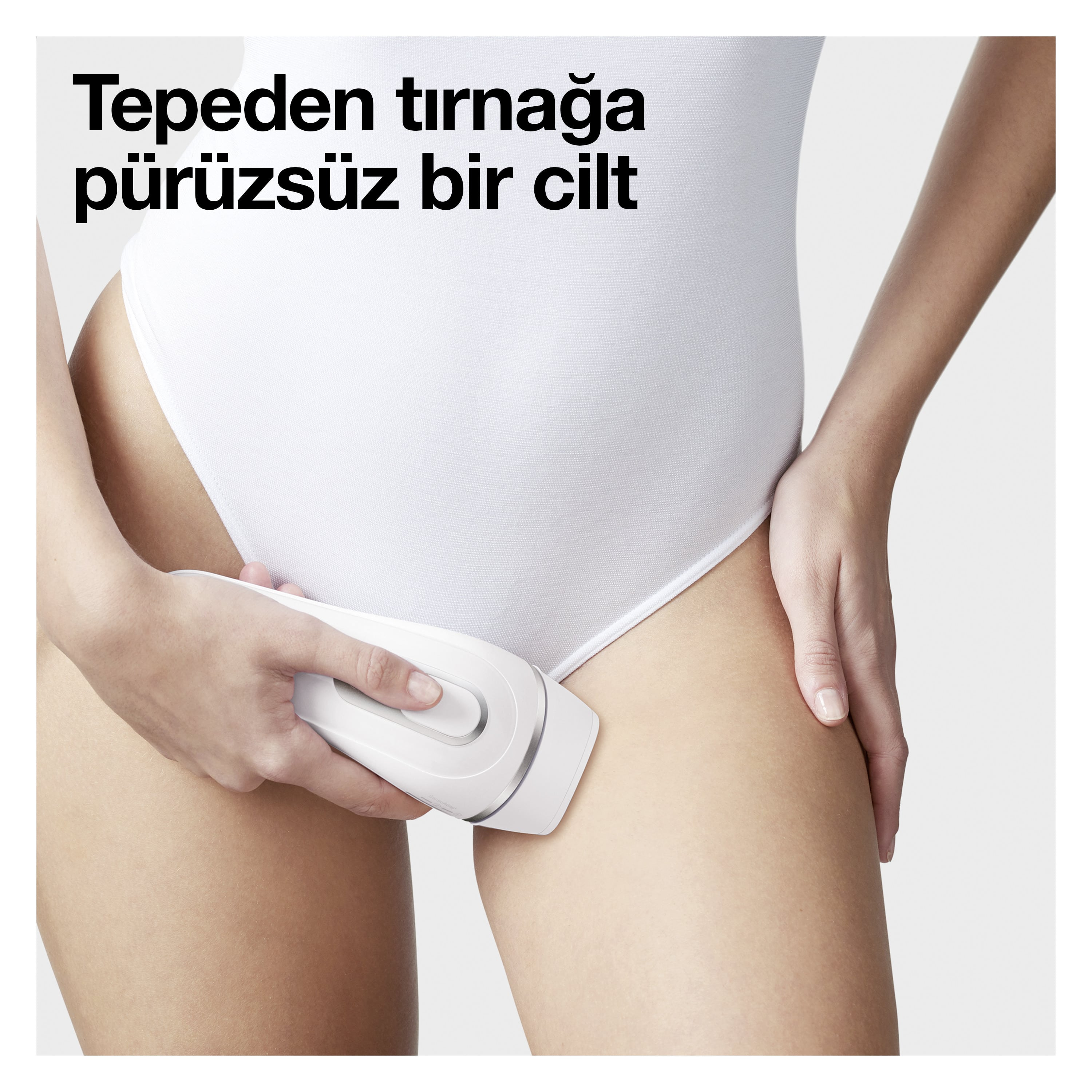 Bir kadın bacağında bir epilasyon cihazı kullanıyor. Cihaz beyaz.