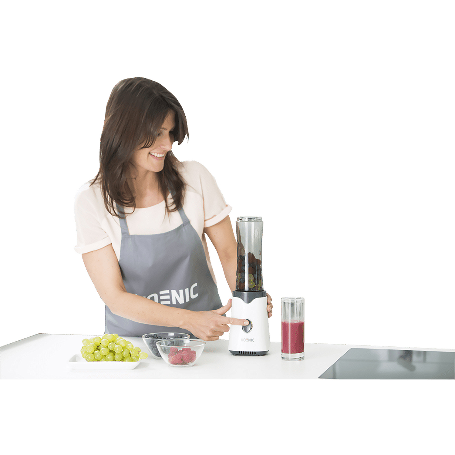 Una donna con i capelli castani corti fa un frullato con un frullatore bianco.