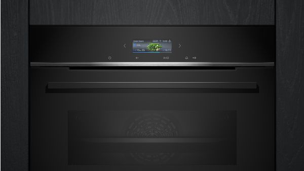 Un horno negro con una pantalla digital que muestra un programa de cocción. Está en una cocina negra.
