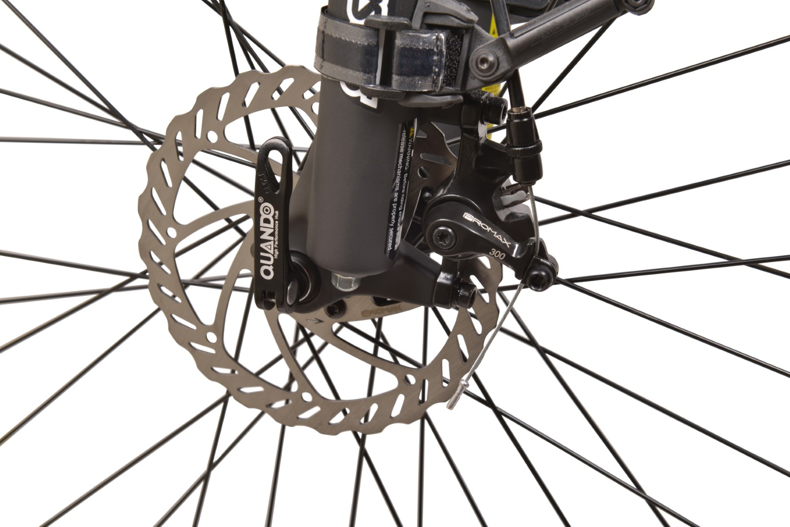 Zbliżenie koła roweru i tarczy hamulcowej. Hamulec jest srebrny.