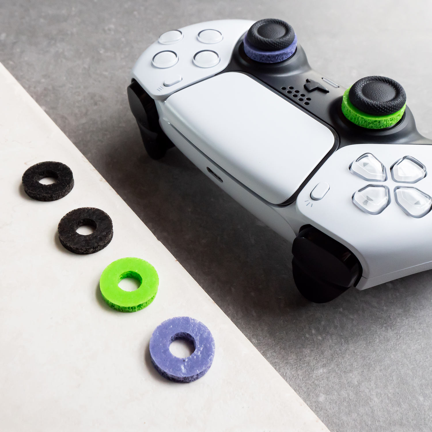 A white and black game controller with colorful thumb grips and button rings.